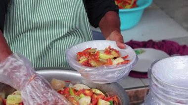 Yerel Endonezyalı satıcı geleneksel pazar geçmişi için plastik kasede taze rujak meyve salatası servis ediyor.