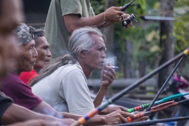 6 Haziran 2025 'te Lombok, Endonezya' da elinde olta tutarken sigara içen yaşlı bir adamın portresi