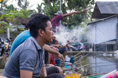 Kırsal kesim üyeleri 6 Haziran 2025 'te Lombok, Endonezya' da çubuklarla tatlı su balıkçılığı yapıyor.