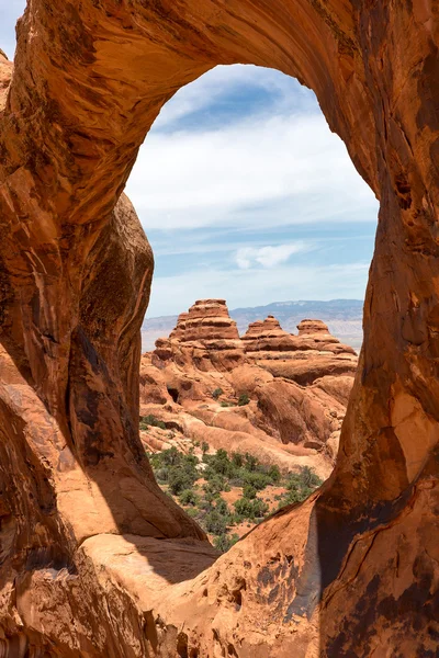 Red rock cliffs viewed through round arch — Stock Photo, Image