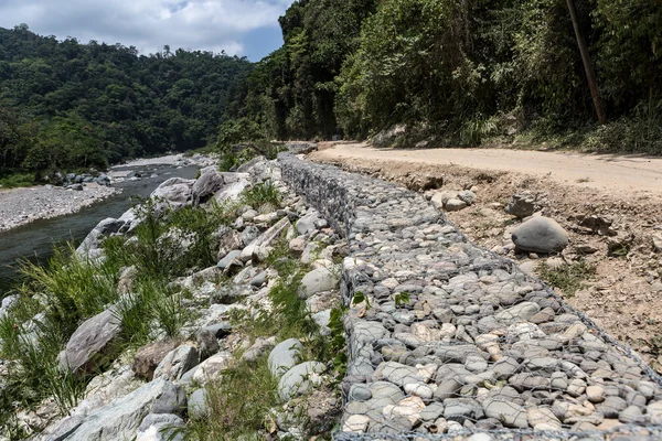 Treillis métallique et mur de soutènement rocheux le long de la route au Honduras — Photo