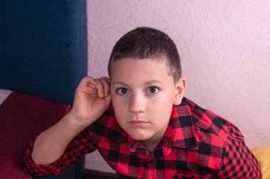 Avrupalı bir gencin portresi açık kahverengi saçlı, kırmızı ekose gömlek giyen.