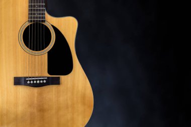 Siyah yankesicili klasik sarı akustik gitar ve izole edilmiş siyah arka plan yakınlarındaki teller.