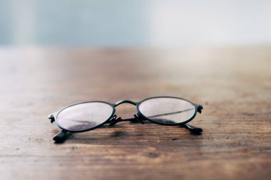 Kötü görüş ya da miyop - Ahşap masa üzerinde okuma gözlükleri yakın çekim yumuşak odak