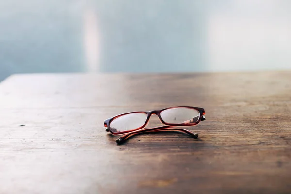 Writing desk for old writers - Reading glasses for elderly on wooden table close-up soft focus