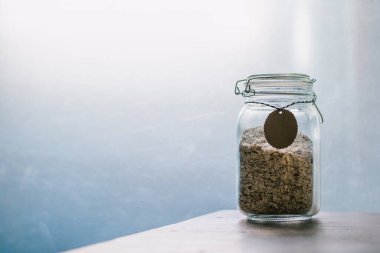 Düşük glisemik indeksli sağlıklı yüksek lifli kahvaltı - cam kavanozdaki yulaf ezmesi taneleri mavi ışık