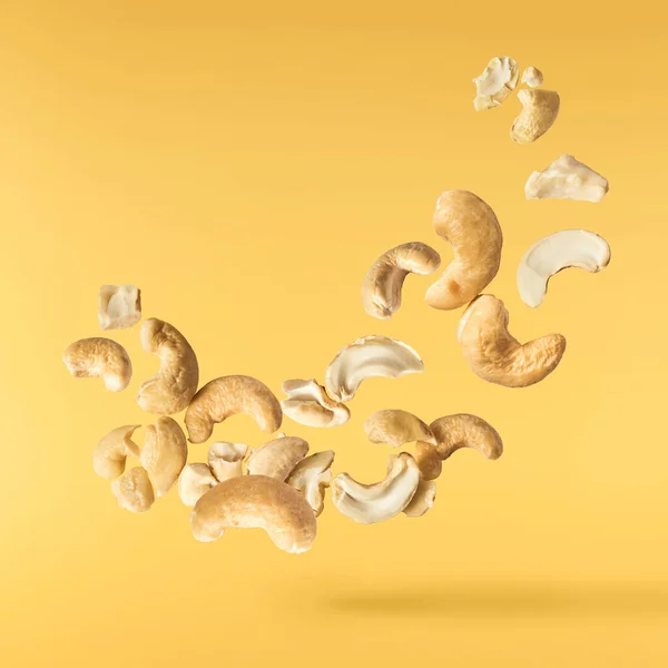 Havaya Düşen Taze Kaju Fıstıkları Sarı Aydınlatıcı Arka Planda Izole — Stok fotoğraf