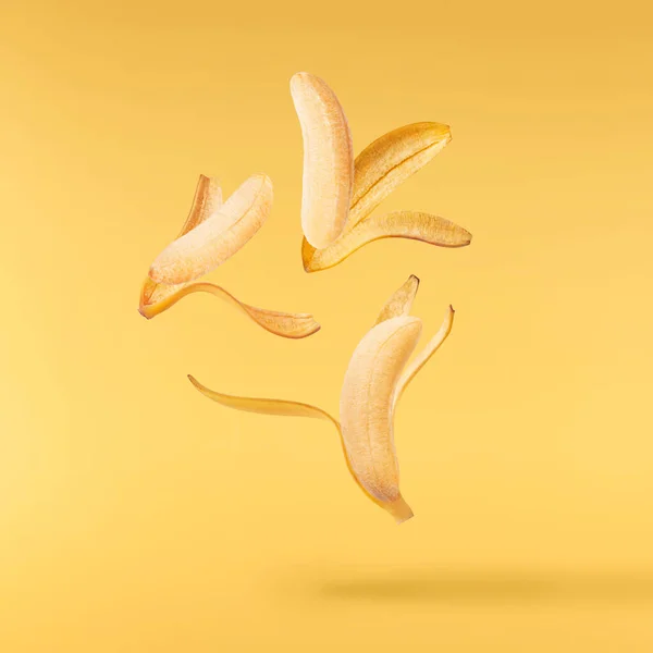 Свіжі Стиглі Дитячі Банани Падають Повітрі Ізольовані Жовтому Тлі Концепція — стокове фото
