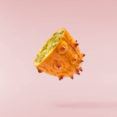 Havaya düşen taze kiwano pembe arka planda izole edilmiş. Sıfır yerçekimi ya da havada kalma. Yüksek kaliteli çözünürlük resmi