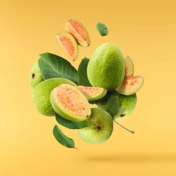 Friss Érett Felezett Guava Levelekkel Levegőben Sárga Megvilágító Háttérrel Elszigetelve — Stock Fotó