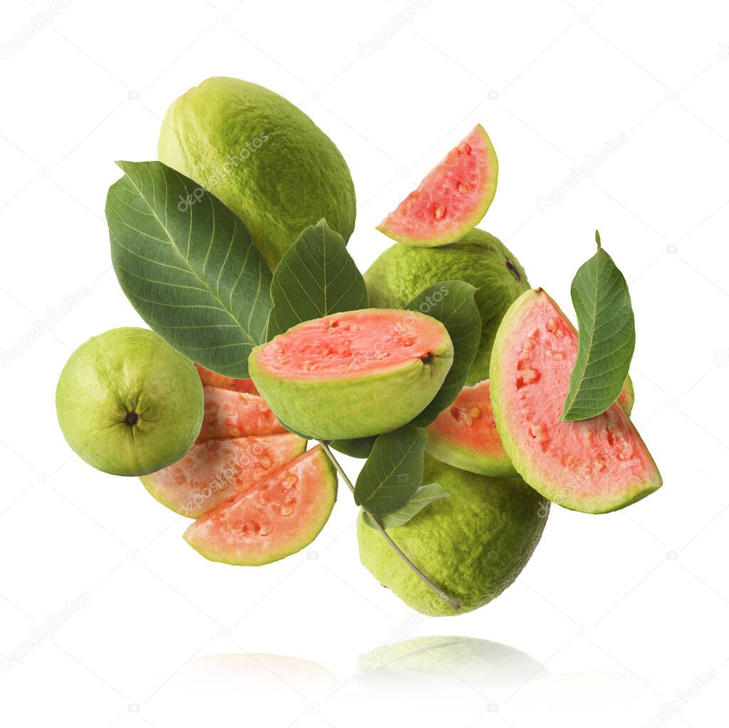 Fresh ripe whole and halved guava with leaves falling in the air isolated on white background. Zero gravity or levitation conception. High quality resolution image