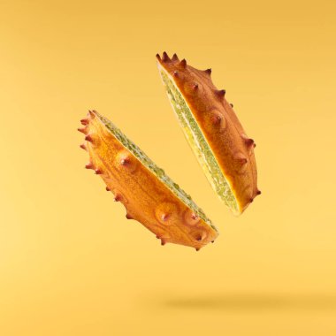 Havaya düşen taze kiwano sarı arka planda izole edilmiş. Sıfır yerçekimi ya da havada kalma. Yüksek kaliteli çözünürlük resmi