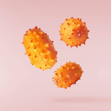 Havaya düşen taze kiwano pembe arka planda izole edilmiş. Sıfır yerçekimi ya da havada kalma. Yüksek kaliteli çözünürlük resmi