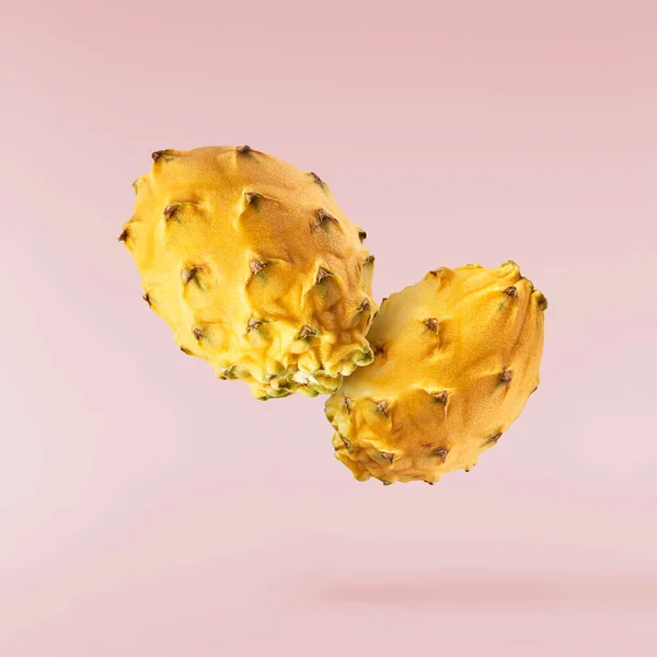 富有创意的形象 新鲜的黄色龙果或番石榴落在空气中 与粉色的背面隔绝 悬浮或零重力食物的概念 高分辨率图像 — 图库照片