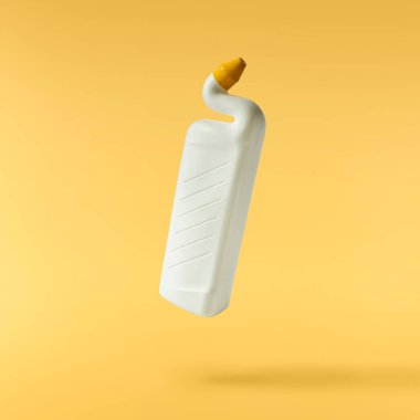 Ev temizlik ürünü. Sarı arka planda izole edilmiş plastik bir şişe havaya düşüyor. Markan için ürün modeli.