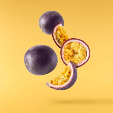 Taze ham tutku meyvesi, sarı arka planda izole bir şekilde havaya düşüyor. Sıfır yerçekimi ve yiyecek havada kalma kavramı. Yüksek çözünürlük