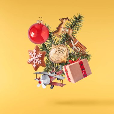 Noel kartı. Havada düşen hediyeler, hediye kutuları ve sarı arka planda izole edilmiş noel ağacı. Noel heykelciği. Yükselme ya da sıfır yerçekimi kavramı. Yüksek çözünürlük.