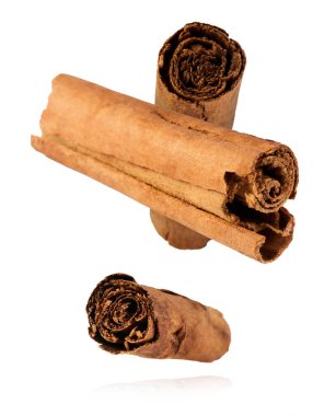 Taze kurutulmuş çiğ tarçın çubuğu beyaz arka planda izole bir şekilde havaya düşüyor. Yiyecek baharatları havada uçuyor ya da yerçekimi sıfır. Yüksek çözünürlük.