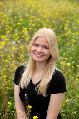 Çiçeklerle çevrili alana sarışın kız