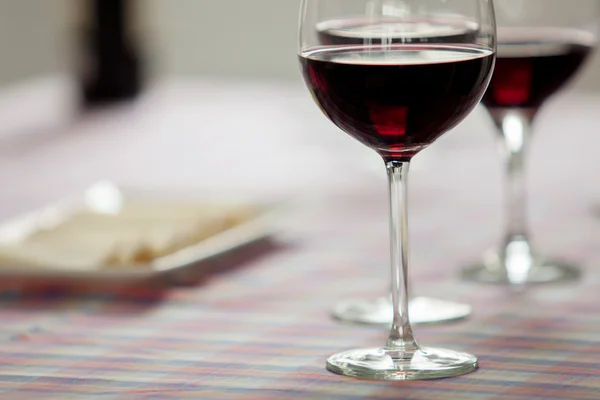 Vasos de vino tinto y bandeja de queso — Foto de Stock