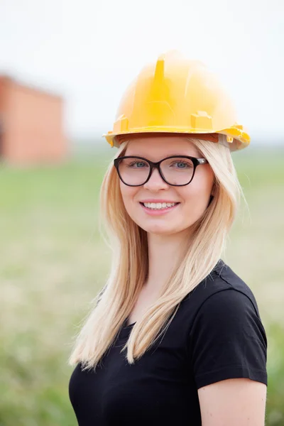 Giovane donna architetto con casco giallo — Foto Stock