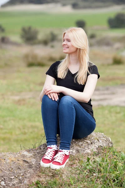 Menina bonita sentada em pedra grande — Fotografia de Stock