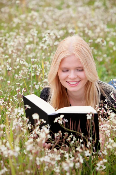 Mujer joven leyendo un libro en el prado — Foto de Stock