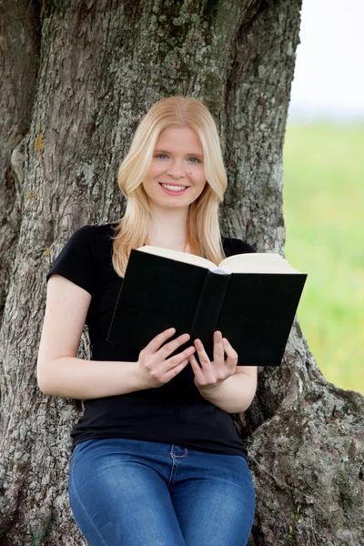 Woman reading a book under tree — Stock Photo, Image