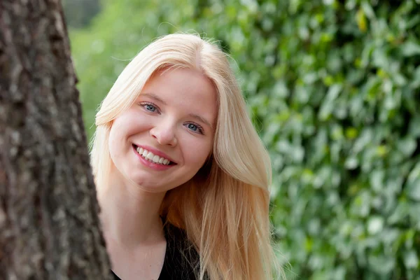 Mujer asomándose desde el árbol — Foto de Stock