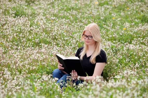 Mujer joven leyendo un libro en el prado — Foto de Stock