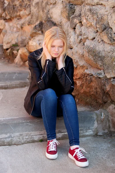 Cool blond flicka sitter utomhus — Stockfoto