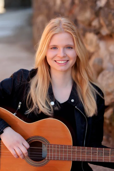 Blonde girl playing guitar outdoor — Stock Photo, Image