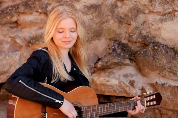 Blond meisje spelen gitaar buiten — Stockfoto