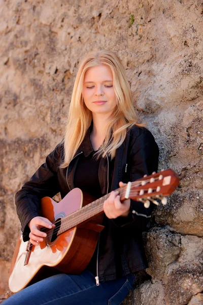 Blonde girl playing guitar outdoor — Stock Photo, Image