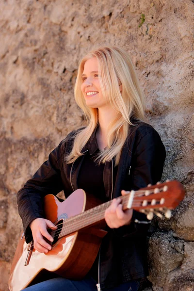 Blond meisje spelen gitaar buiten — Stockfoto