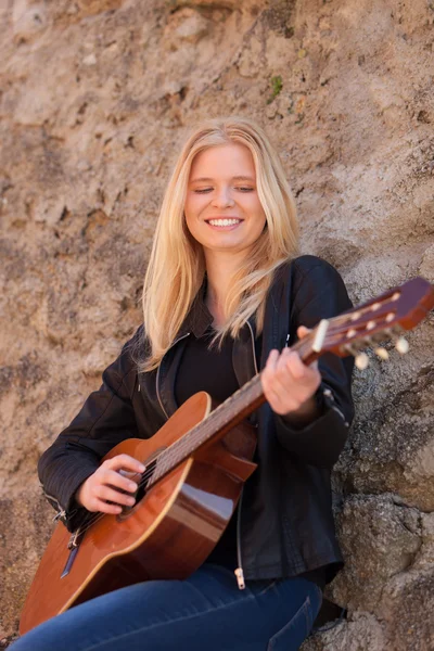 Blonde girl playing guitar outdoor — Stock Photo, Image