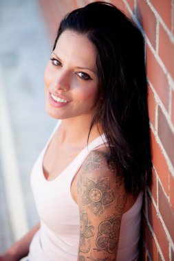 Kırmızı tuğla duvar ile güzel esmer