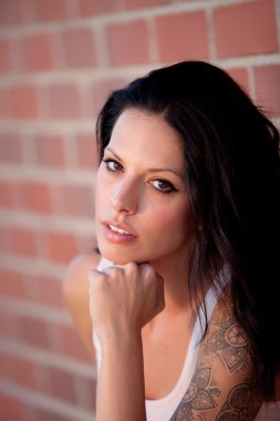 Kırmızı tuğla duvar arka plan ile güzel esmer