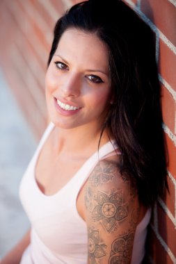 Kırmızı tuğla duvar arka plan ile güzel esmer