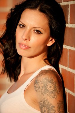 Kırmızı tuğla duvar arka plan ile güzel esmer