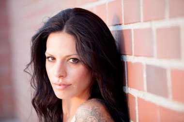 Kırmızı tuğla duvar arka plan ile güzel esmer