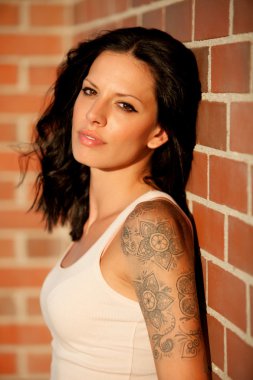 Kırmızı tuğla duvar arka plan ile güzel esmer