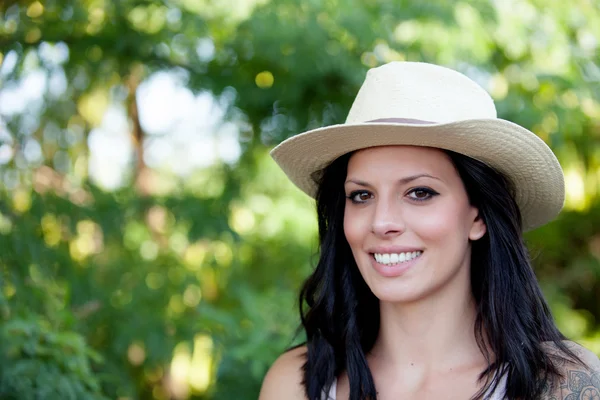 Brunette woman with straw hat walking — Stock Photo, Image