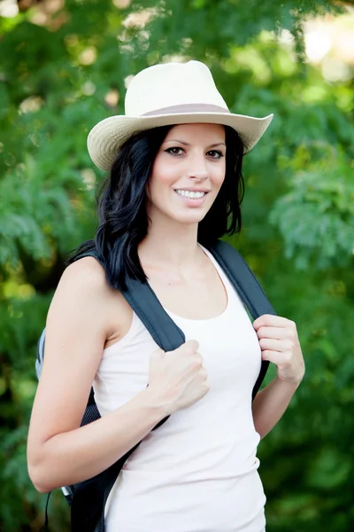 Hasır şapka yürüme ile esmer kadın