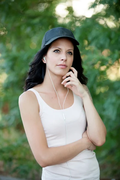 Brunett kvinna med hörlurar lyssna musik promenader i fo — Stockfoto
