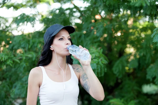 Beautiful woman drinking water while hiking — Stock Photo, Image