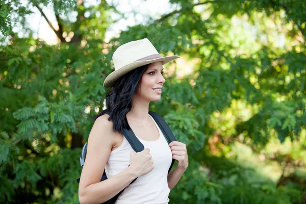 Brunette woman with straw hat walking — Stock Photo, Image