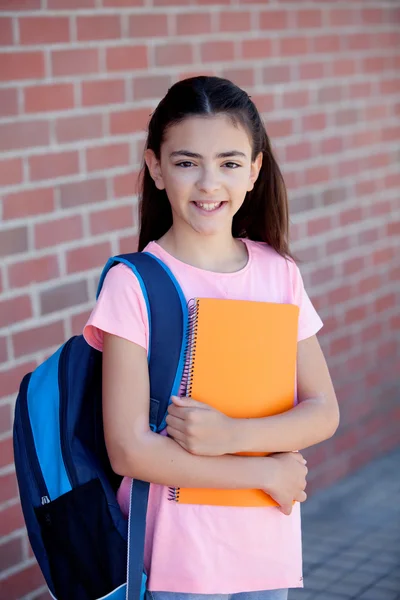 Menina pré-adolescente com mochila e livro — Fotografia de Stock