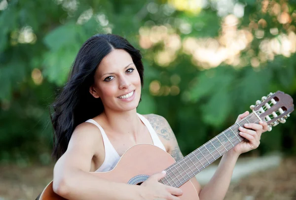 Brunett vacker kvinna med en gitarr — Stockfoto