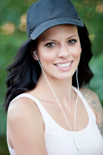 Bruna donna con le cuffie ascoltare musica a piedi nel fo — Foto Stock